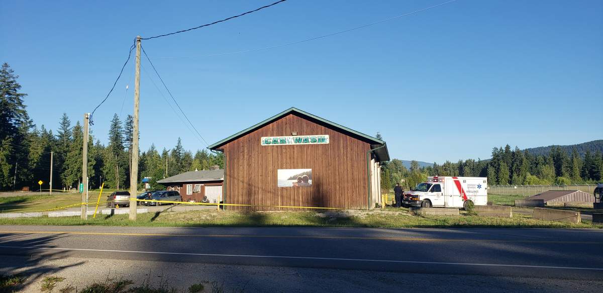 FILE. A view of the car wash in Scotch Creek, B.C., surrounded by police tape and with an ambulance out front.