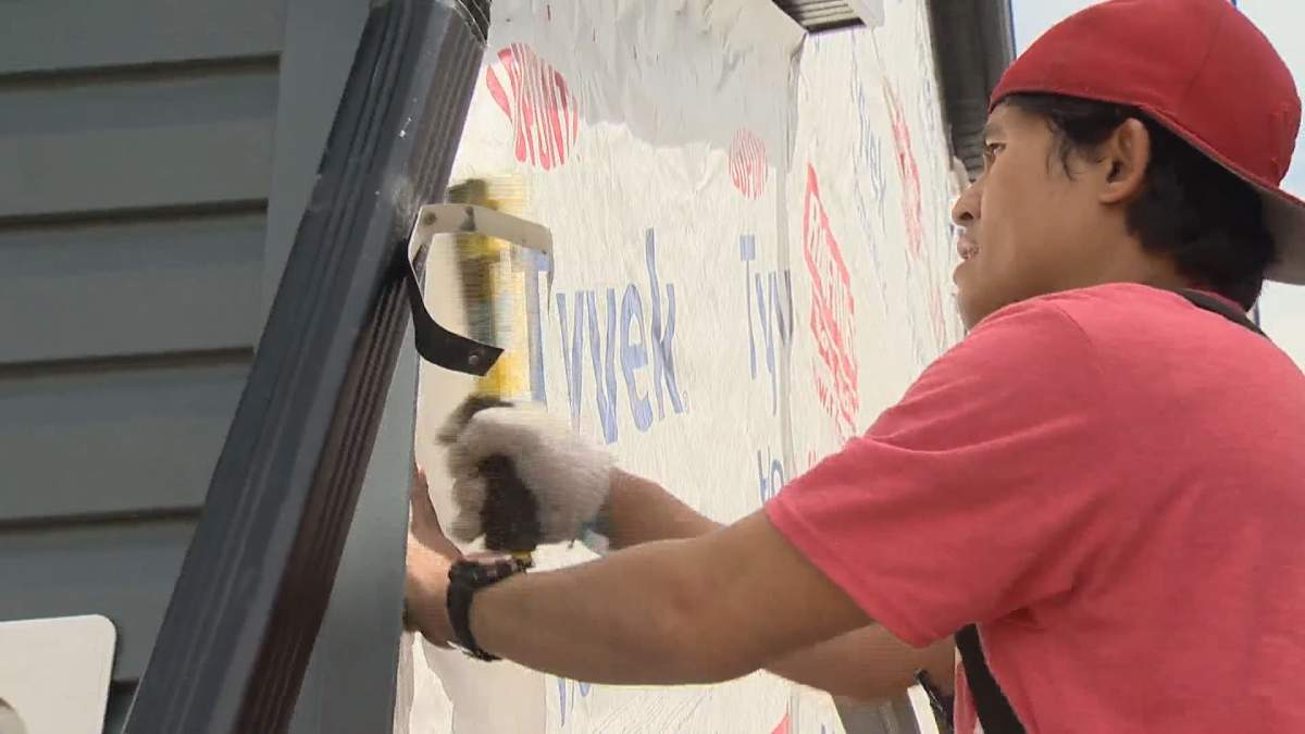 Skilled employee with Epic Group does some siding work on Calgary home