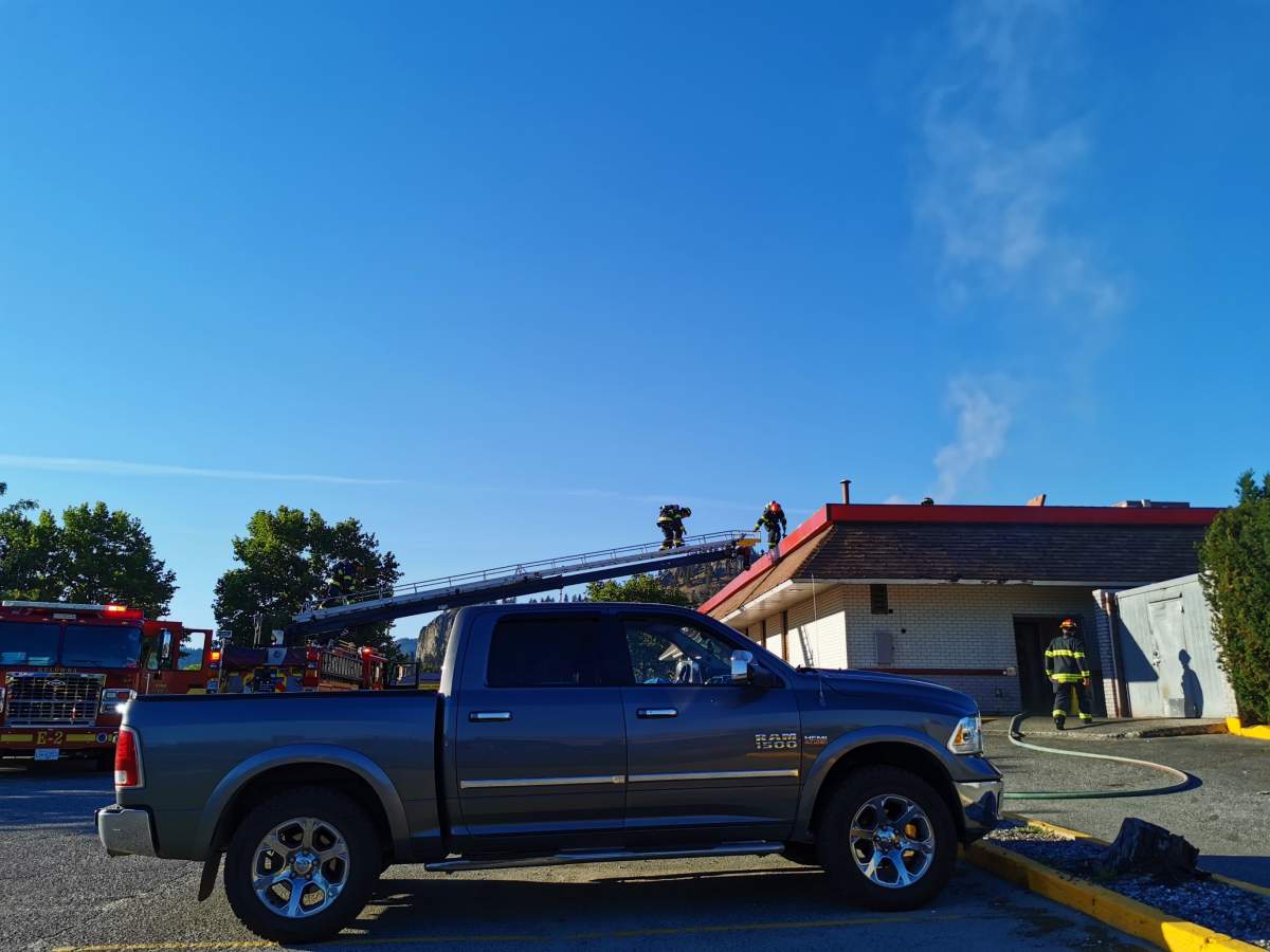 Firefighters climb onto the roof of Burger King in Kelowna to extinguish a mechanical fire.