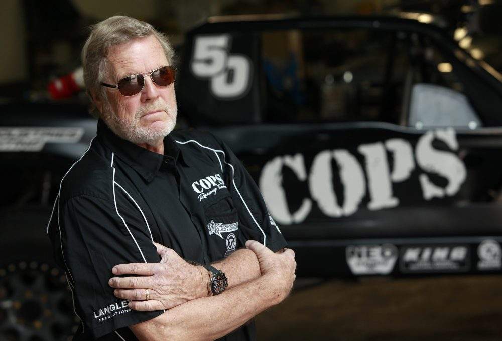 John Langley poses with a 'Cops' off-road racer in El Segundo, Calif., on Nov. 1, 2012.
