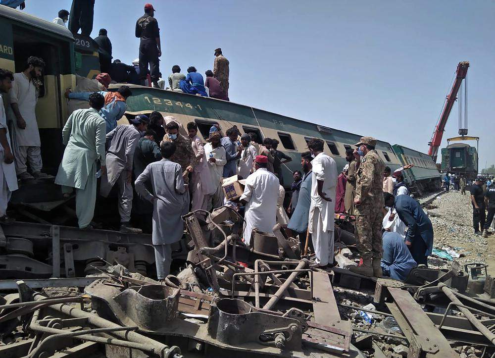 Soldiers and volunteers work at the site of a train collision in Ghotki district in southern Pakistan, Monday, June 7, 2021.