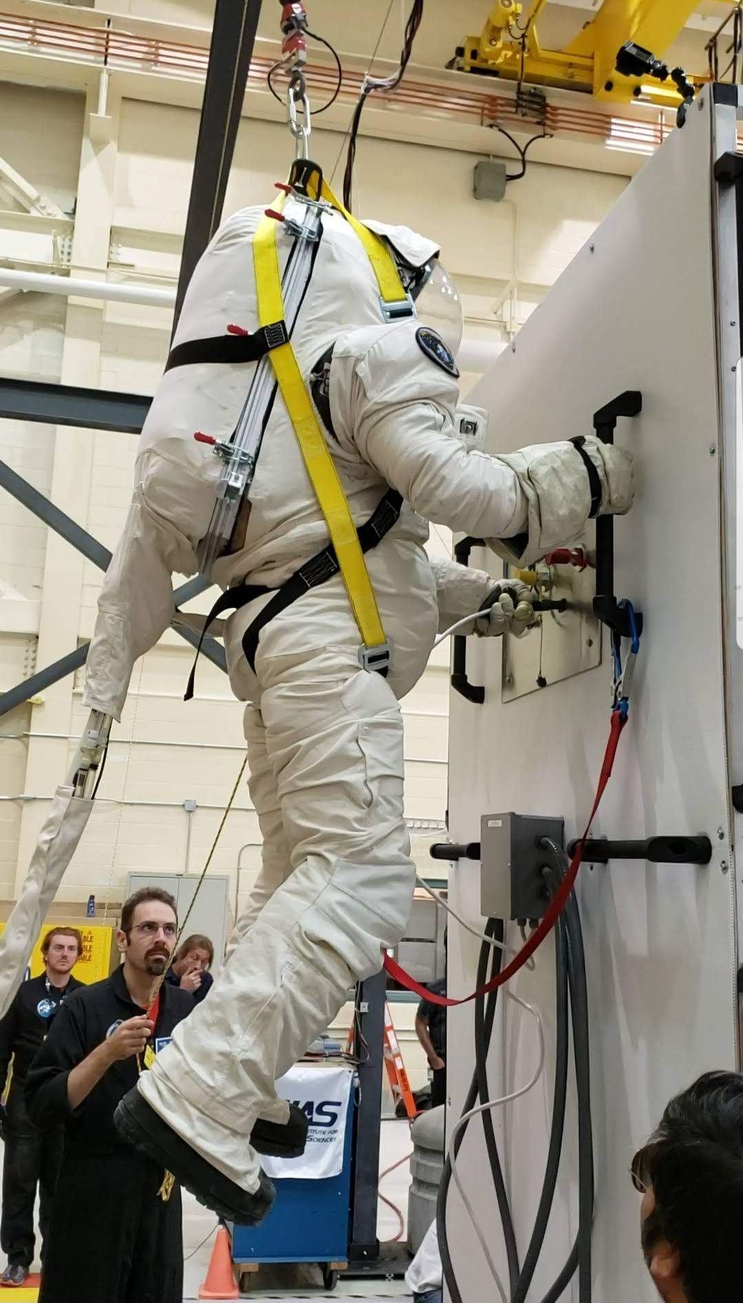 Dr. Shawna Pandya tests the Final Frontier Design EVA (extra-vehicular activity) spacesuit in a gravity offset system in the Canadian Space Agency’s High Bay during the 2019 Project PoSSUM gravity offset course.