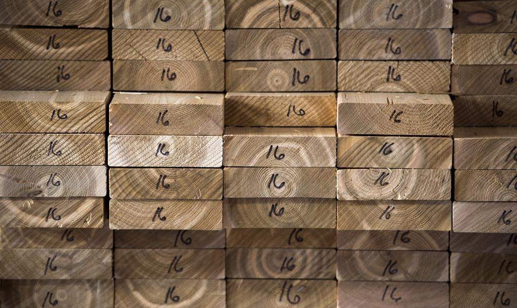 Cedar planks are stacked at a lumber yard, Tuesday, April 25, 2017 in Montreal. Canfor Corp. says it is curtailing production capacity at its Canadian sawmills beginning Monday as a result of extreme wildfire conditions in Western Canada. THE CANADIAN PRESS/Paul Chiasson.