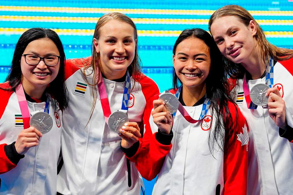Canada’s Margaret Mac Neil, left to right, Rebecca Smith, Kayla Sanchez and Penny Oleksiak celebrate a silver medal in the women’s 4 x 100m freestyle relay during the Tokyo Olympics in Tokyo, Japan on Sunday, July 25, 2021.
