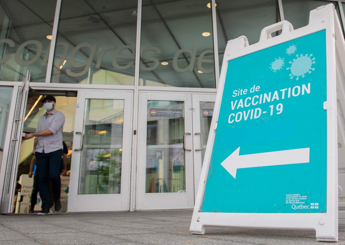 A man wears a face mask as he leaves a COVID-19 vaccination site in Montreal, Sunday, July 4, 2021. THE CANADIAN PRESS/Graham Hughe.