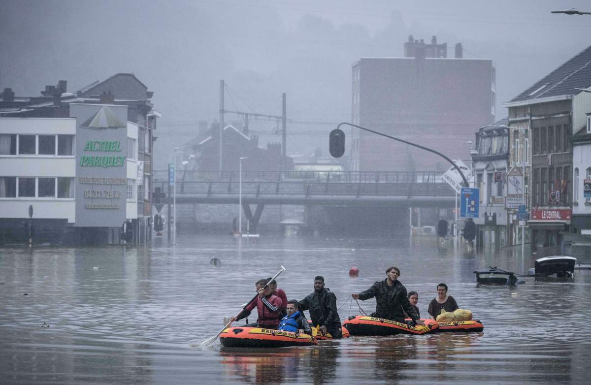 People use rubber rafts in floodwaters after the Meuse River broke its banks during heavy flooding in Liege, Belgium, Thursday, July 15, 2021.