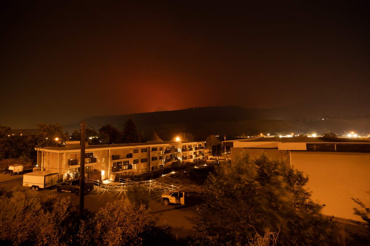 The sky glows orange as the Tremont Creek wildfire burns on a mountain in the distance above Ashcroft, B.C., on Thursday, July 15, 2021. 