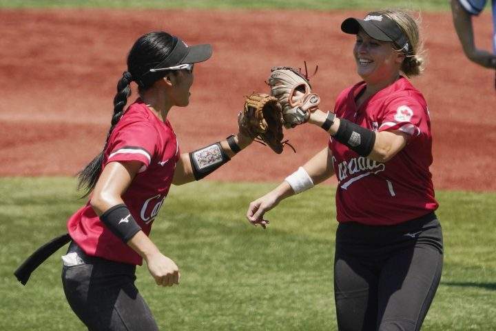 Canada’s Janet Leung, left, and Kelsey Harshman, right, celebrate in the fifth inning of a softball game against Australia in Yokohama Baseball Stadium at the 2020 Summer Olympics, Saturday, July 24, 2021, in Yokohama, Japan. (AP Photo/Sue Ogrocki)