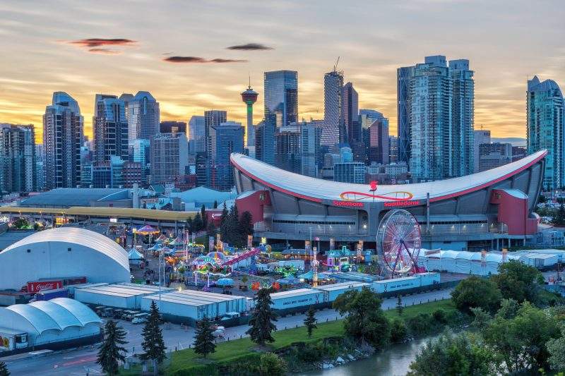 Sunset over Calgary skyline with the annual Stampede event at the Saddledome grounds.