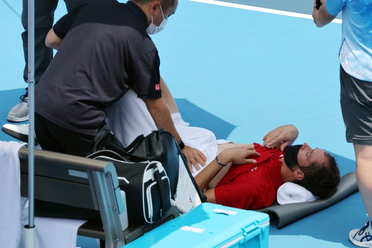 Russia’s Daniil Medvedev is assisted by a physio during Tokyo 2020 Olympic Games men’s singles third round tennis match against Italy’s Fabio Fognini at the Ariake Tennis Park in Tokyo on July 28, 2021.
