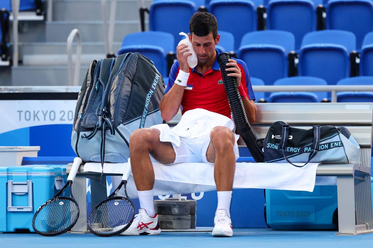 Novak Djokovic tries to keep cool in the blistering heat with a portable air conditioner and ice during the Men’s Tennis Round 3 match on July 28, 2021, in Tokyo, Japan.