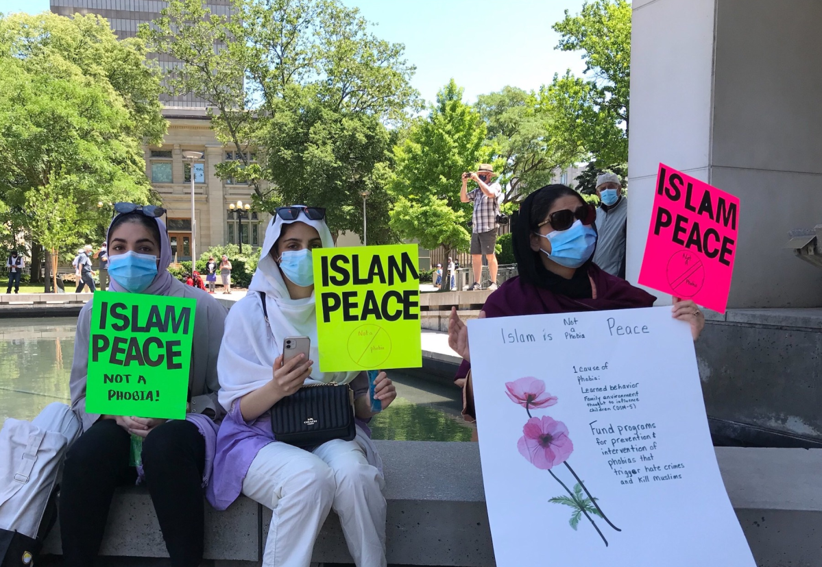 Attendees of a vigil in front of Hamilton city hall hold signs condemning Islamophobia following the attack on a Muslim family in London last month.