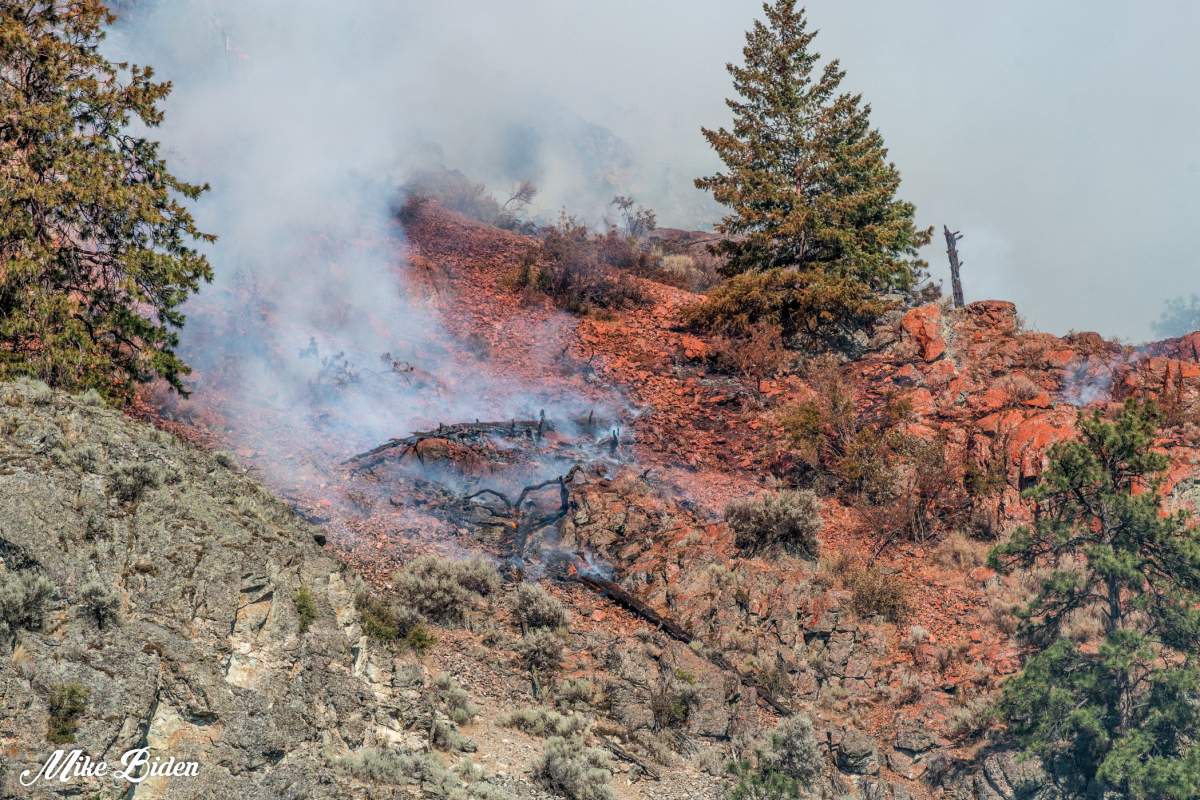 Red retardant stains a stretch of hillside as air tankers battle the Thomas Creek wildfire east of Skaha Lake near Penticton, B.C.