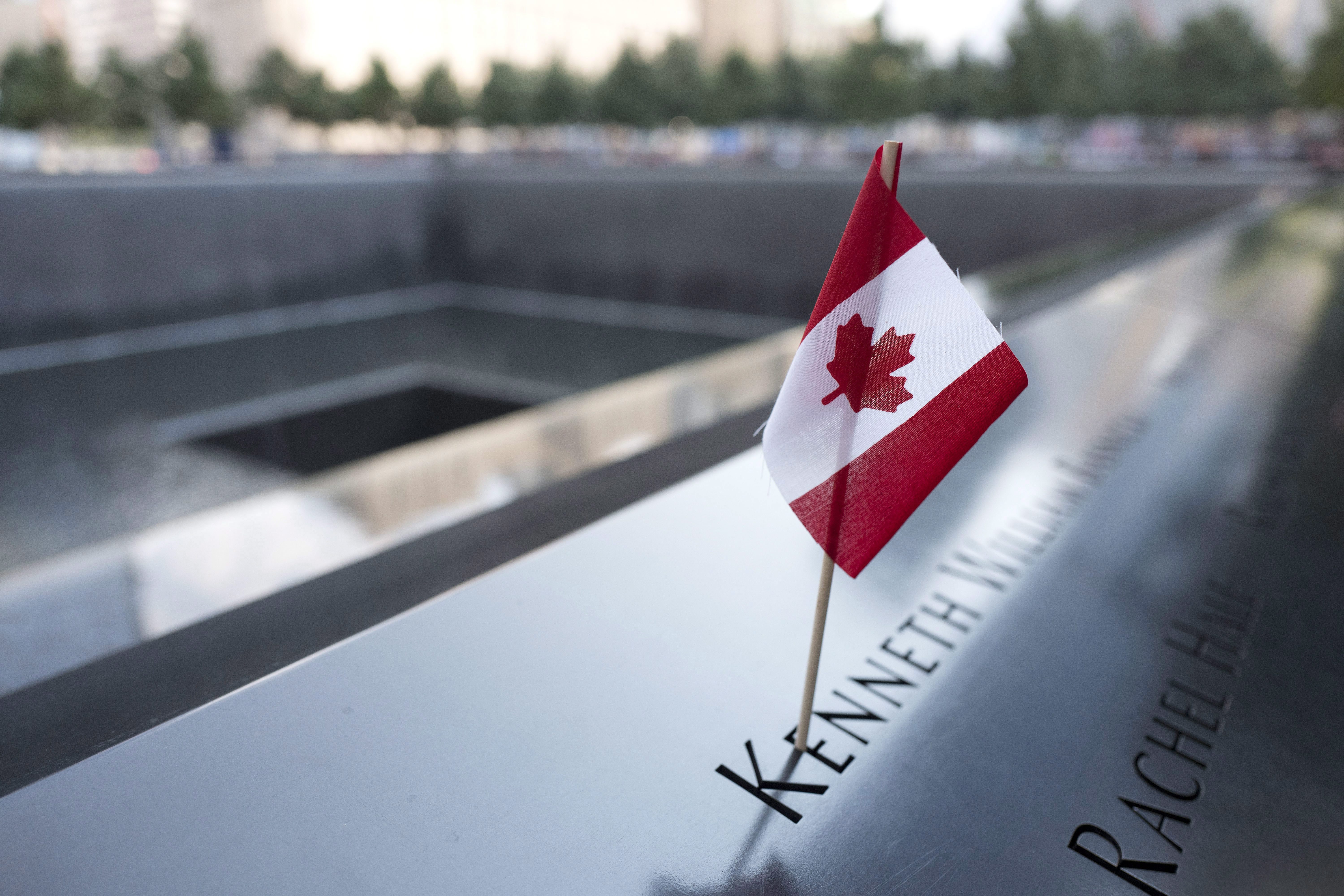 A Canadian flag is placed at the name of Kenneth William Basnicki at the North Pool of the National September 11 Memorial, Tuesday, Sept. 5, 2017, in New York. (AP Photo/Mark Lennihan)