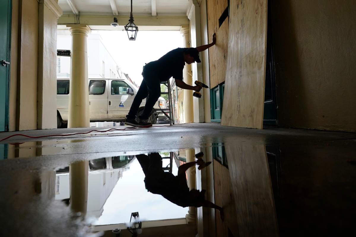 In preparation of Hurricane Ida, a worker attaches protective plywood to windows and doors of a business in the French Quarter in New Orleans, Saturday, Aug. 28, 2021. (AP Photo/Eric Gay)