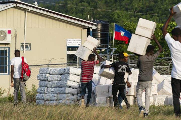 Haitian aid workers move aid boxes after unloading a VM-22 Osprey at Jeremie Airport, Saturday, Aug. 28, 2021, in Jeremie, Haiti.