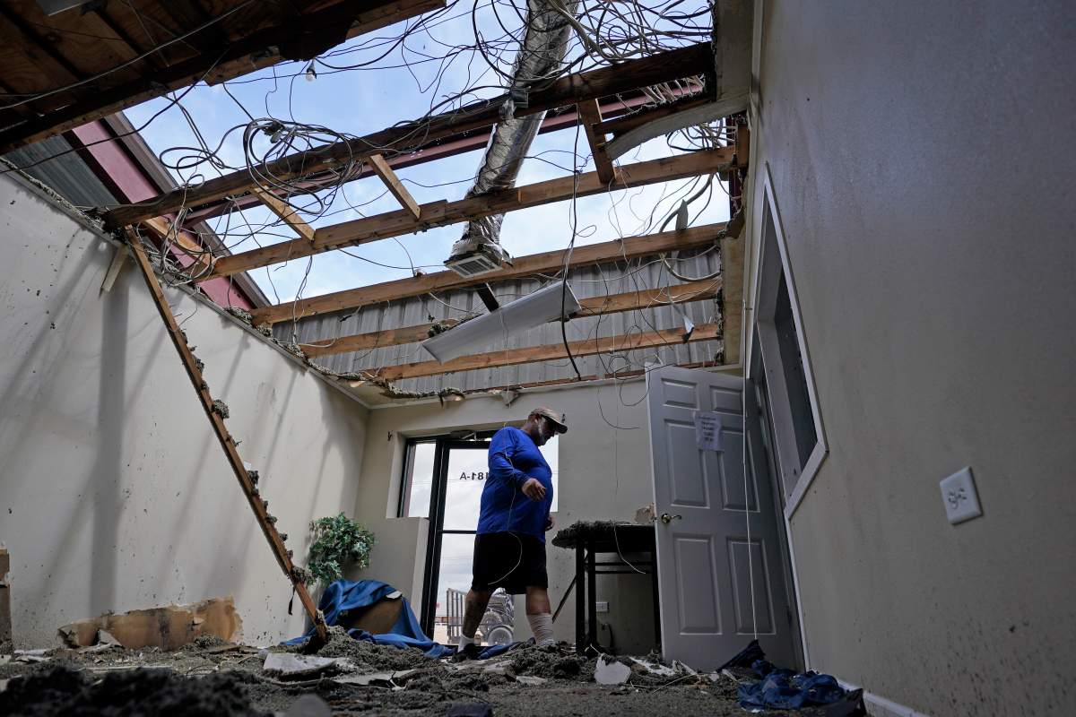 Rene Hebert walks through the family’s destroyed offices as cleans up in the aftermath of Hurricane Ida, Monday, Aug. 30, 2021, in Houma, La. (AP Photo/David J. Phillip)