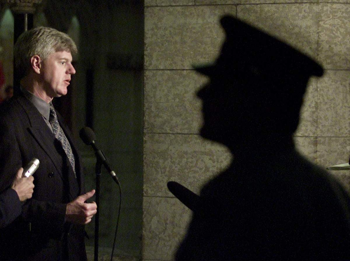 Former foreign affairs minister John Manley is seen here in a Sept 18, 2001 photo speaking to reporters as a security guard stands by following a meeting on Parliament Hill.