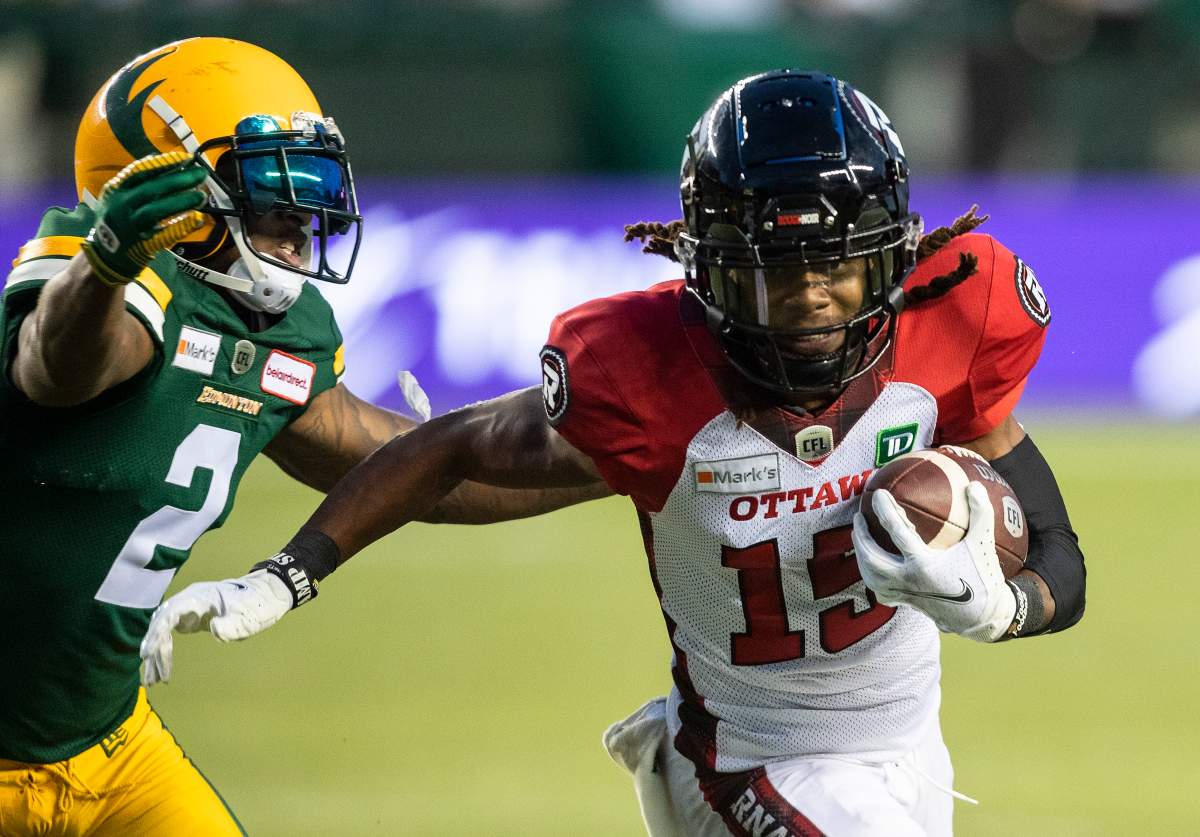 Ottawa Redblacks' Ryan Davis (15) is chased by Edmonton Elks' Jonathon Mincy Sr. (2) during first half CFL action in Edmonton, Alta., on Saturday August 7, 2021. THE CANADIAN PRESS/Jason Franson.