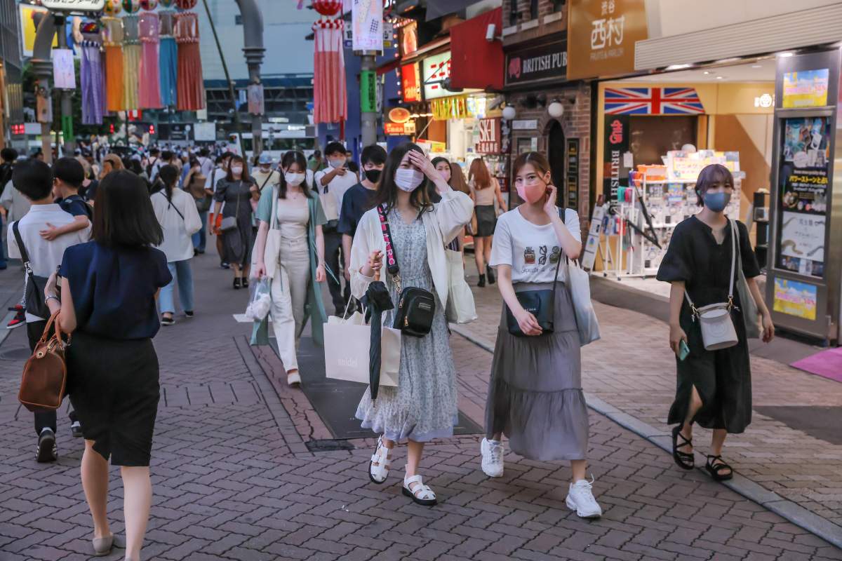 Pedestrians wearing face masks as a precaution against the spread of COVID-19 walk in the streets of Shibuya, amid the COVID-19 pandemic. 