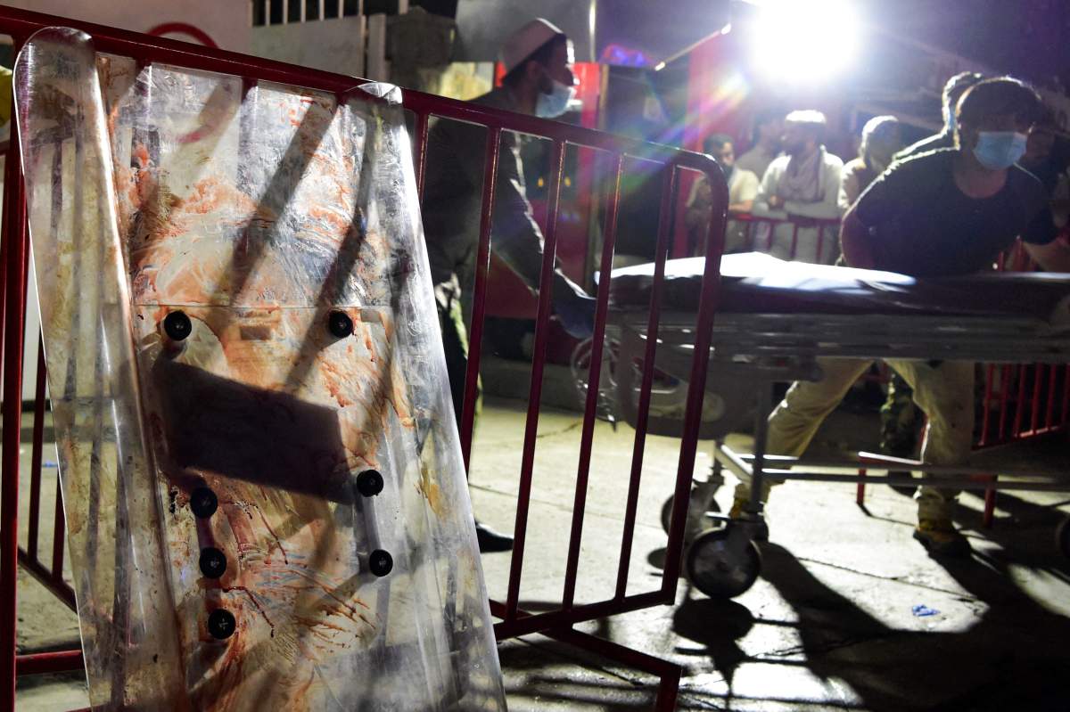 Medical staff move a stretcher to bring injured people for treatment after two powerful explosions, which killed at least six, outside the airport in Kabul on Aug. 26, 2021.