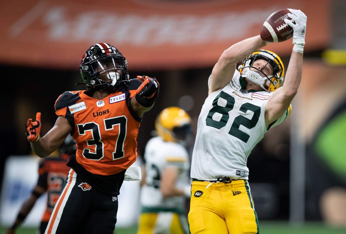 Edmonton Elks' Greg Ellingson (82) makes a reception as B.C. Lions' KiAnte Hardin (37) defends during the second half of a CFL football game in Vancouver, on Thursday August 19, 2021. 