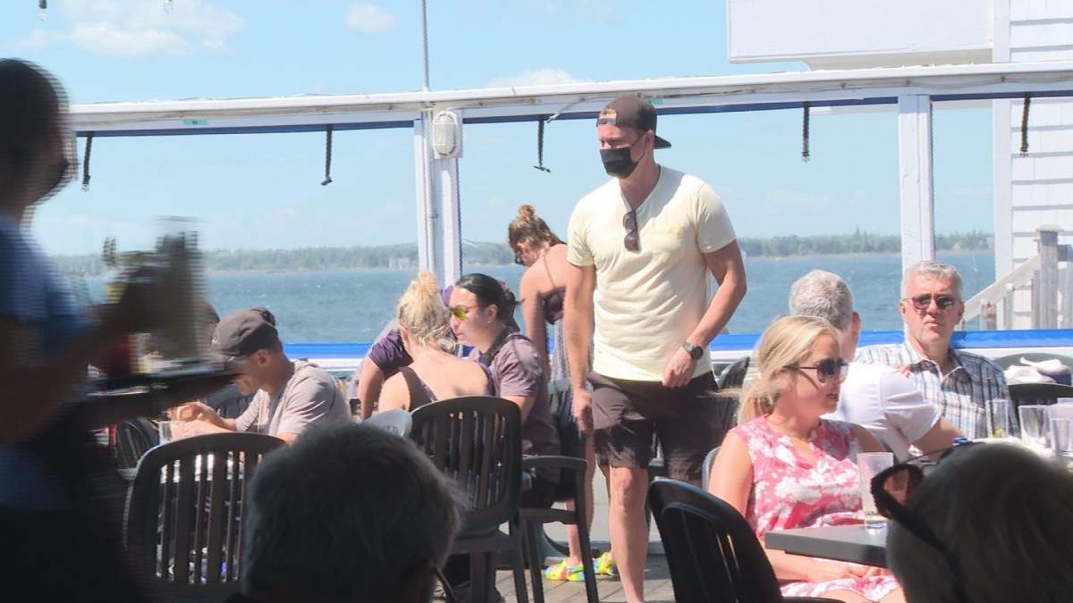 Robert Taylor, the owner of The Sandbar in Pointe-Du-Chêne, checks on customers Tuesday. He is worried about the pressures small businesses are facing, especially with the mandatory order now lifted, but some isolation requirements remaining