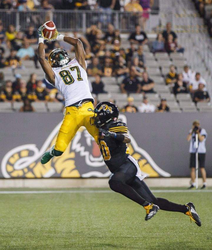Derel Walker catches a touchdown pass against Hamilton Tiger-Cats’ Mariel Cooper, right, during the first half of CFL football action in Hamilton, Ontario on Thursday August 23, 2018.