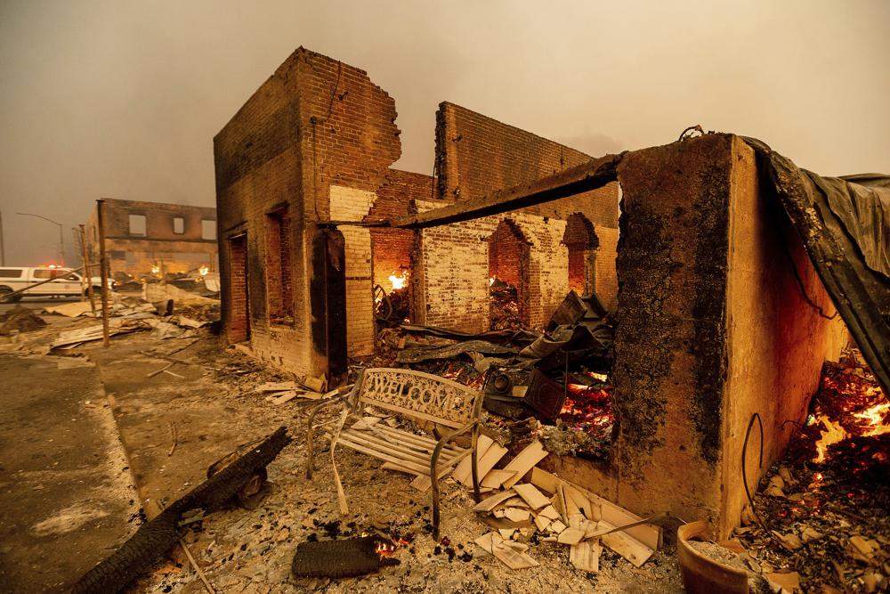 A bench stands outside a scorched building as the Dixie Fire tears through the Greenville community of Plumas County, Calif., on Wednesday, Aug. 4, 2021. The fire leveled multiple historic buildings and dozens of homes in central Greenville.