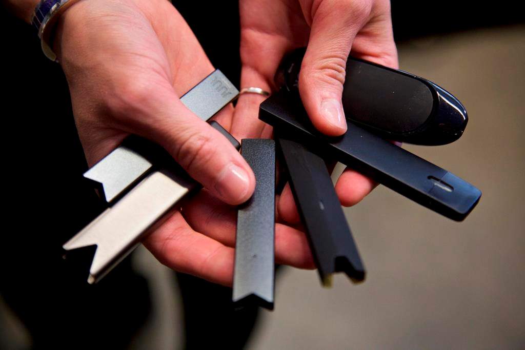 FILE - In this April 16, 2019 file photo, a researcher holds vape pens in a laboratory in Portland, Ore. On Thursday, Sept. 9, 2021, U.S. health officials delayed a high-stakes decision on whether to permit best selling vaping brand Juul to stay on the market, while ordering thousands of other electronic cigarettes off store shelves. (AP Photo/Craig Mitchelldyer, File).