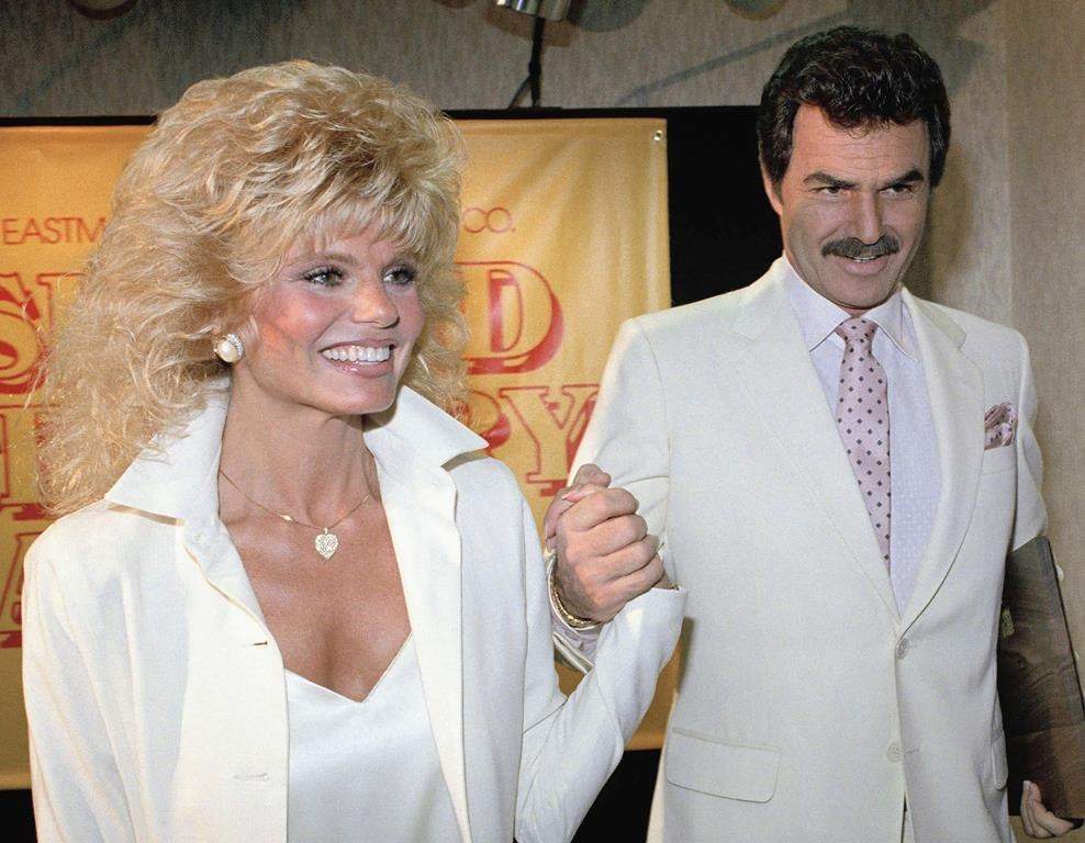 FILE - In this March 27, 1987, file photo, Burt Reynolds, right, holds hands with Loni Anderson at luncheon in Los Angeles.