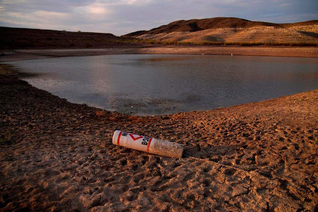 FILE – In this Aug. 13, 2021, file photo a buoy rests on the ground at a closed boat ramp on Lake Mead at the Lake Mead National Recreation Area near Boulder City, Nev.