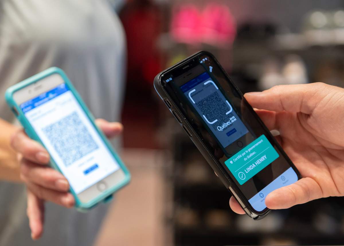 Linda Henry has her COVID-19 QR code scanned in Montreal on Wednesday as Quebec's COVID-19 vaccine passport came into effect. Ontario's vaccine certificate system is also expected to have a QR code component as of late next month.