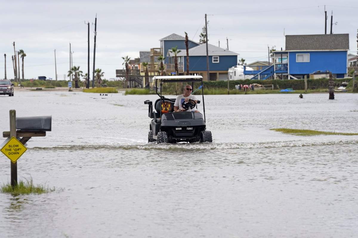 Joe Ward drives down through floodwaters from Hurricane Nicholas Tuesday, Sept. 14, 2021, in Surfside Beach, Texas. (AP Photo/David J. Phillip).