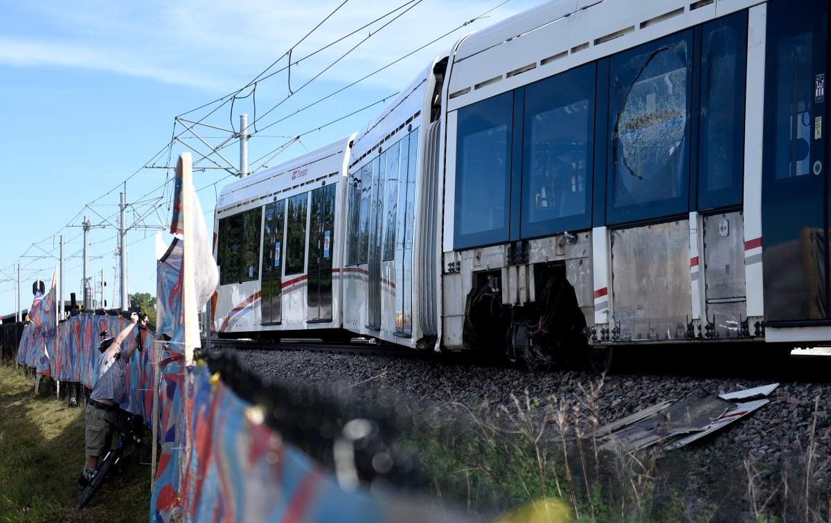 A window is broken and the wheels of a segment of an OC Transpo O-Train is seen west of Tremblay LRT Station  in Ottawa on Monday, Sept. 20, 2021 after it derailed on Sunday. The train has since been moved back to the storage yard. 