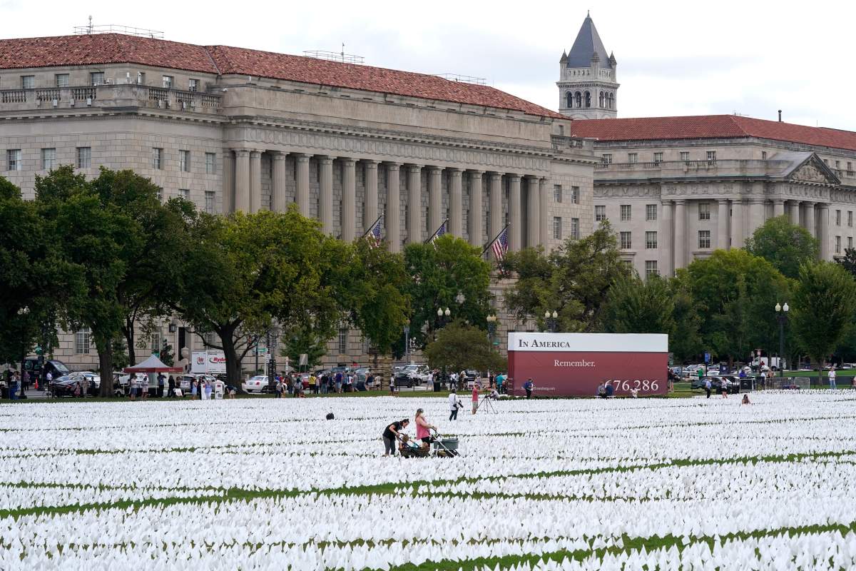 People visit artist Suzanne Brennan Firstenberg’s “In America: Remember,” a temporary art installation made up of white flags to commemorate Americans who have died of COVID-19, on the National Mall in Washington, Tuesday, Sept. 21, 2021. (AP Photo/Patrick Semansky)