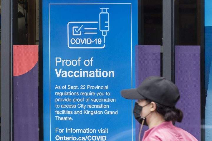 A person wears a mask to protect them from the COVID-19 virus while walking past information about vaccination proof on Thursday September 23, 2021.