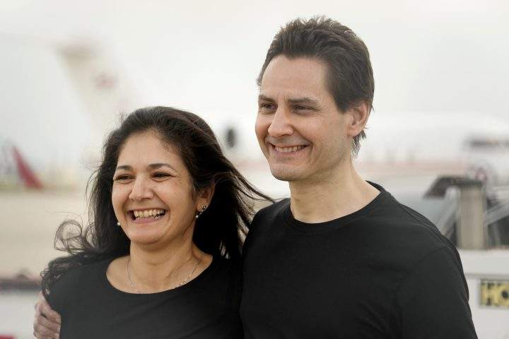 Michael Kovrig embraces his wife Vina Nadjibulla, left, after arriving at Pearson International Airport in Toronto, Saturday, Sept. 25, 2021.