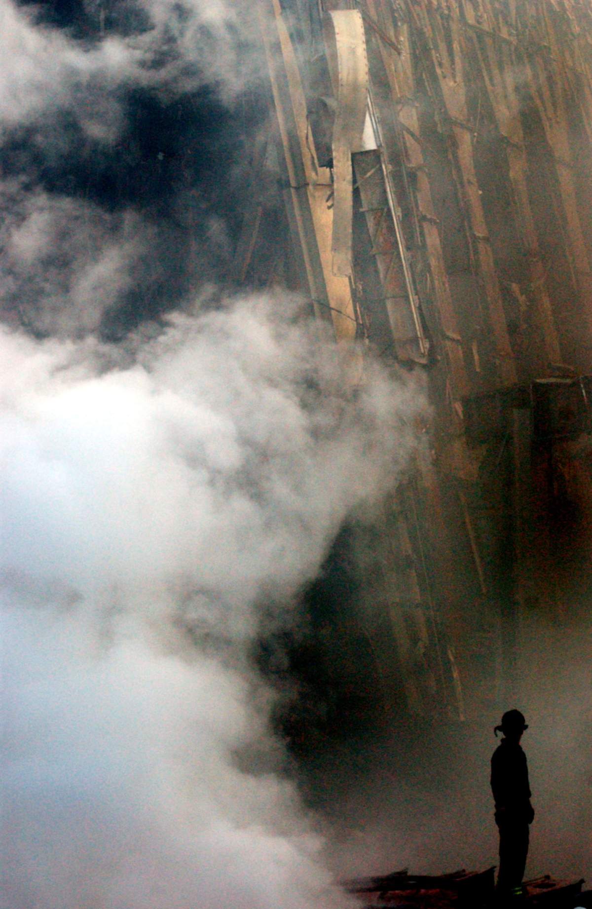 A solitary firefighter stands amidst the rubble and smoke of the World Trade Center Sept. 14, 2001.