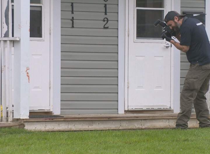 A member of the Regina police forensics team captures images at the scene of the crime of an alleged attempted murder on Friday, Aug. 27, 2021 at a residence in the Gladmer Park neighbourhood.