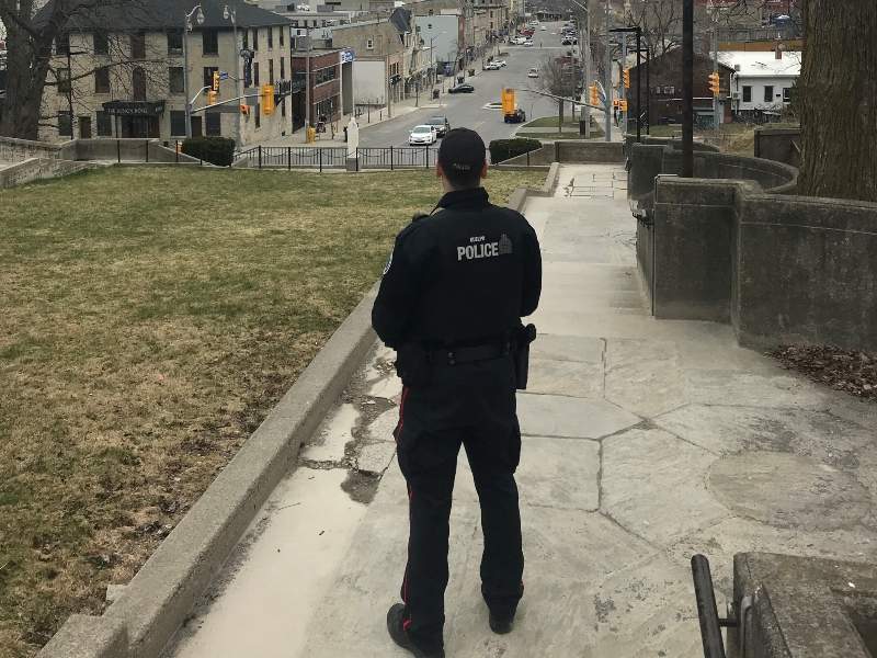 Guelph police officer stands looking towards the downtown.