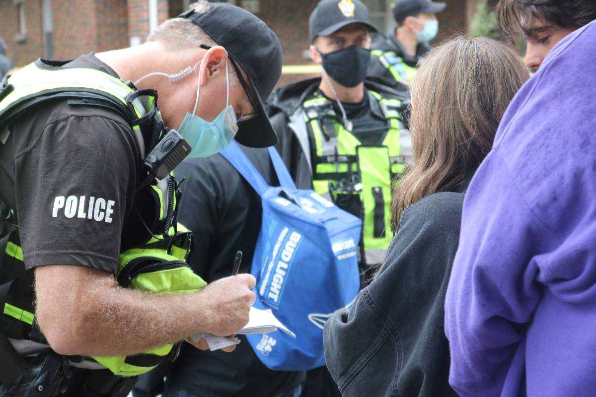 London police officer ticking a young adult for having an open container of alcohol on the street during Western’s homecoming weekend. Sept. 25, 2021