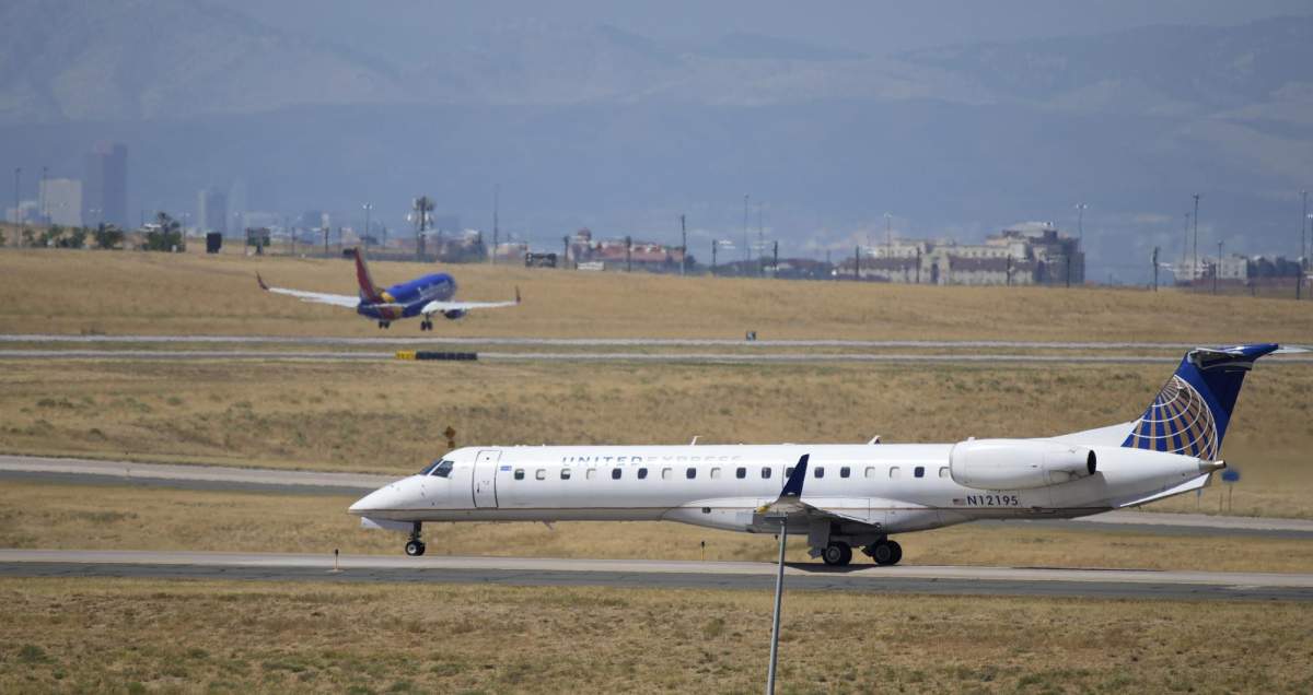 A United Express jet taxis down a runway as a Southwest Airlines plane takes off in the background at Denver International Airport, Tuesday, Aug. 24, 2021, in Denver. (AP Photo/David Zalubowski)