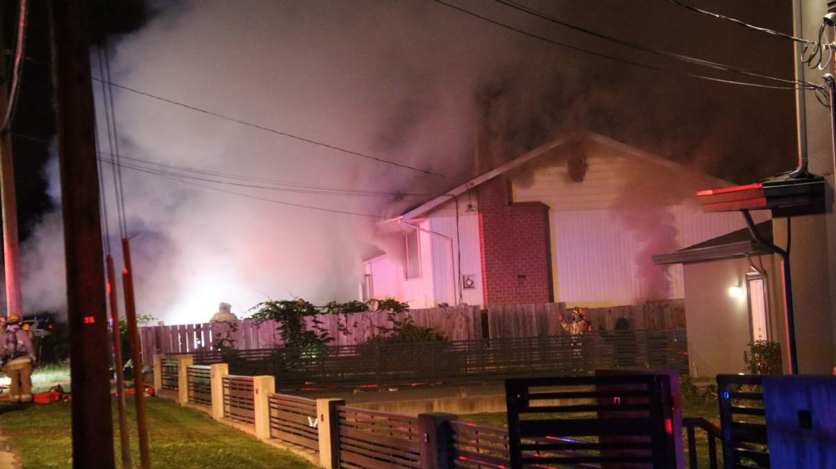 Smoke and flames pour out of a house on the 4400 Block of Victory Street in Burnaby, B.C. on Sept. 28, 2021. The Burnaby Fire Department says the cause of the house fire is still under investigation.