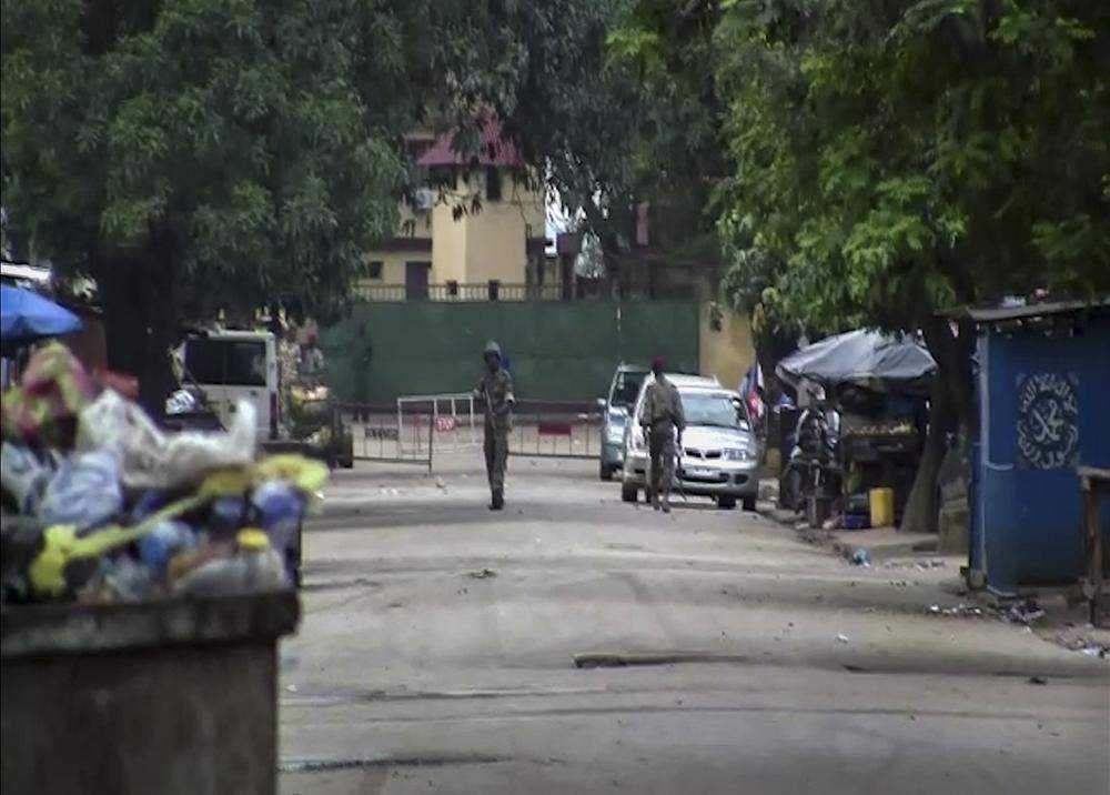 In this image made from video, unidentified soldiers are seen near the presidential palace in the capital Conakry, Guinea Sunday, Sept. 5, 2021. Mutinous soldiers detained President Alpha Conde on Sunday after hours of heavy gunfire rang out near the presidential palace, then announced on state television that the government had been dissolved in an apparent coup d’etat. (AP Photo)