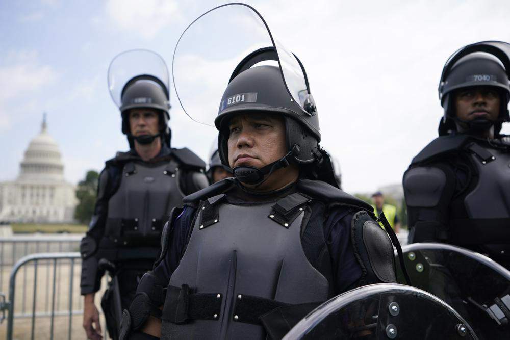 Police in riot gear patrol as people attend a rally near the U.S. Capitol in Washington, Saturday, Sept. 18, 2021. The rally was planned by allies of former President Donald Trump and aimed at supporting the so-called “political prisoners” of the Jan. 6 insurrection at the U.S. Capitol. (AP Photo/Brynn Anderson)