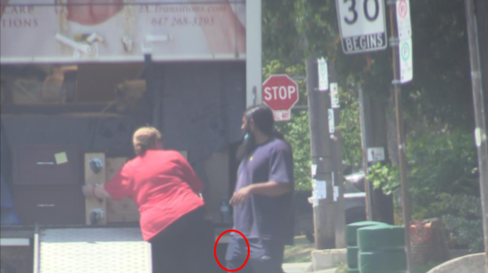 Surveillance photo of man identified by police as Kevin Omar Mohamed. Police alleged the red circle marks the smartphone in his pocket, a probation violation.