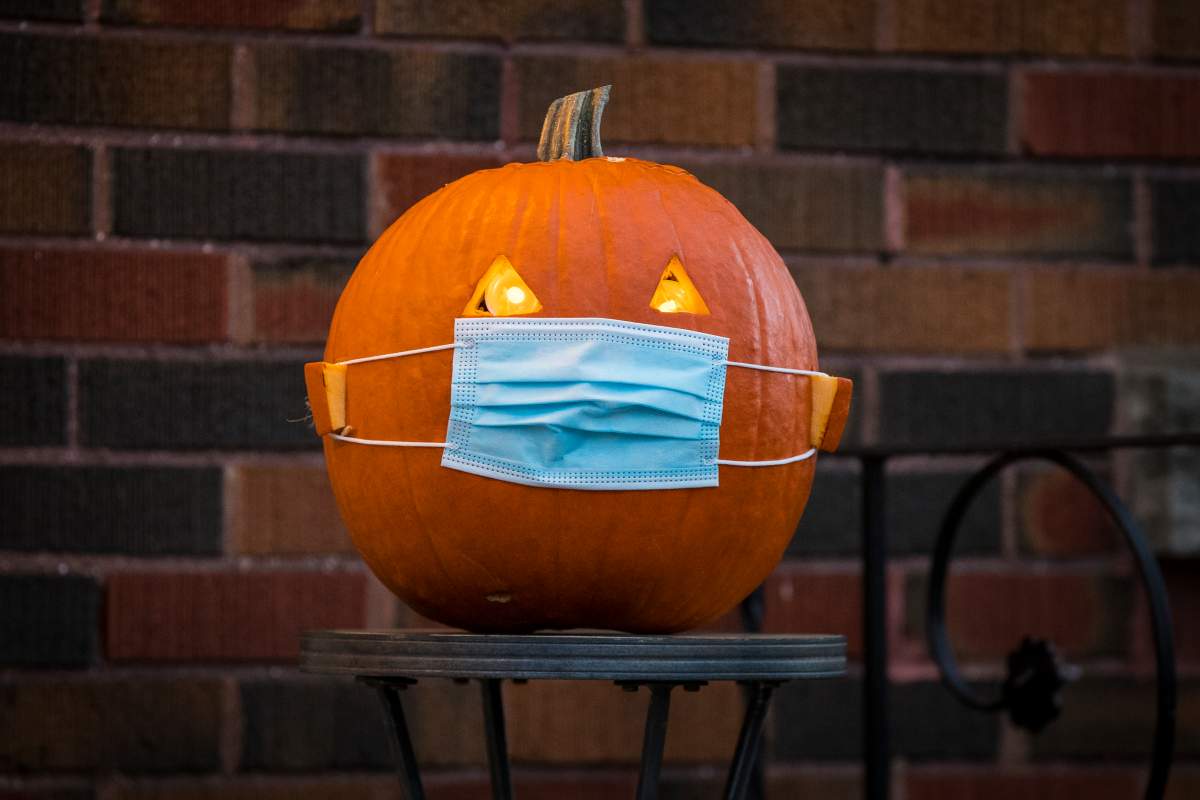 A halloween pumpkin wears a mask in Kingston, Ontario on Saturday, October 31, 2020, as the COVID-19 pandemic continues across Canada and around the world. THE CANADIAN PRESS IMAGES/Lars Hagberg.