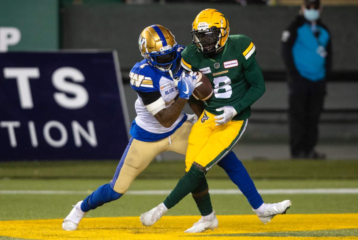Winnipeg Blue Bombers' Darvin Adams (1) tries to stop Edmonton Elks' Trumaine Washington (8) as he makes the interception during first half CFL action in Edmonton, Alta., on Saturday, September 18, 2021. 
