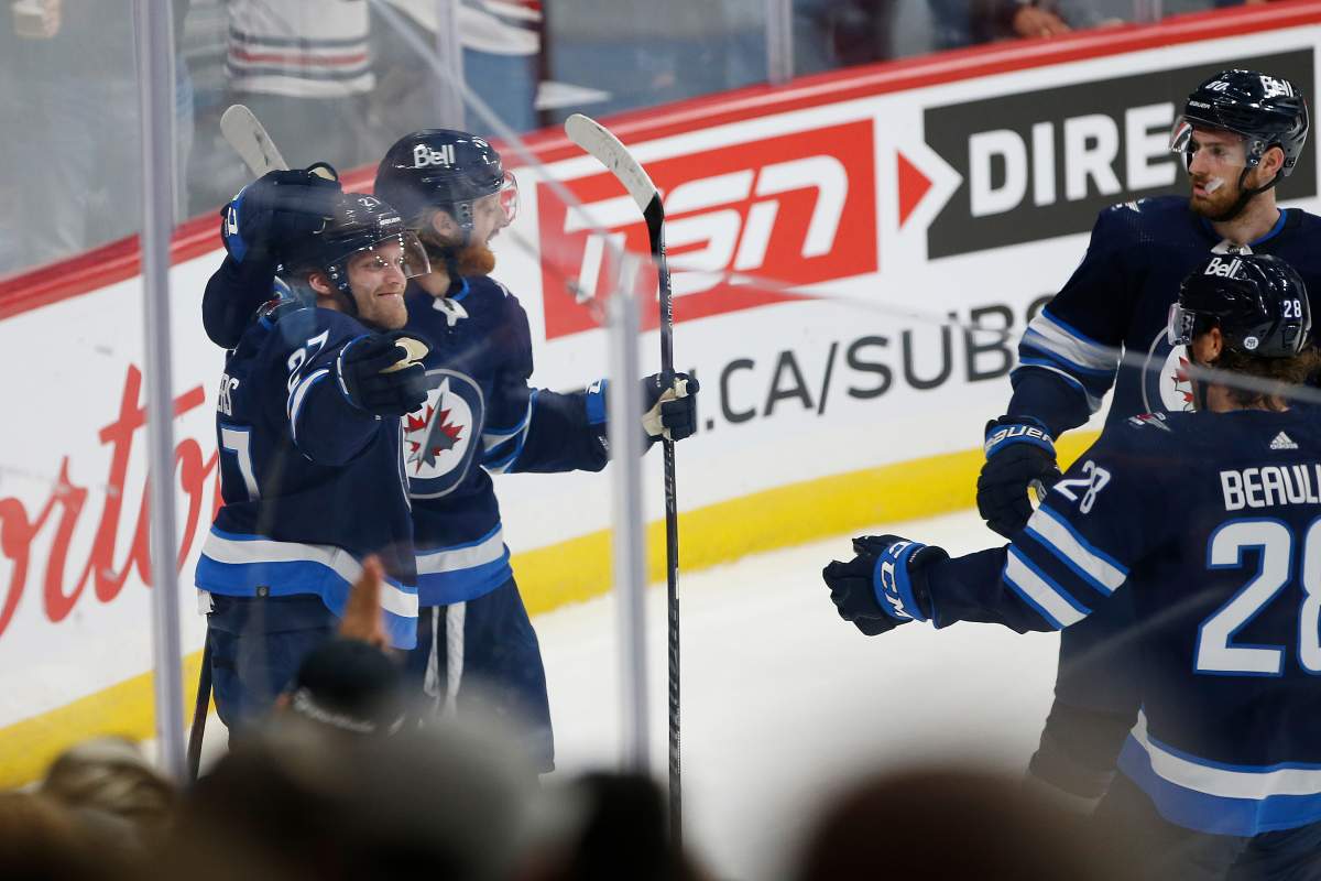 Winnipeg Jets’ Nikolaj Ehlers (27) celebrates his goal with teammates Kyle Connor (81), Pierre-Luc Dubois (80) and Nathan Beaulieu (28) against the Calgary Flames during first period NHL pre-season game action in Winnipeg on Oct. 6, 2021. THE CANADIAN PRESS/John Woods